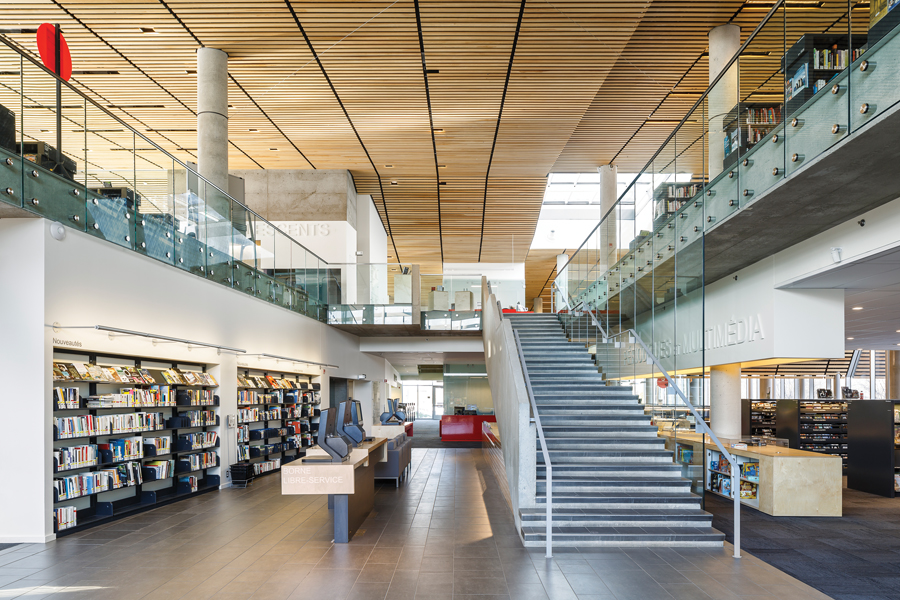 A view of the library lobby reveals a prominent staircase leading to the second floor.