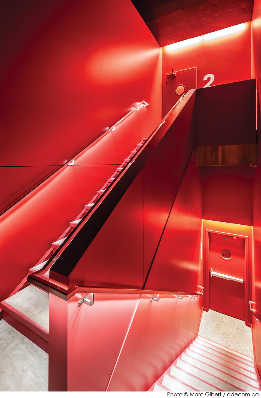 A bright red stairway maintains the project’s minimalist colour palette.