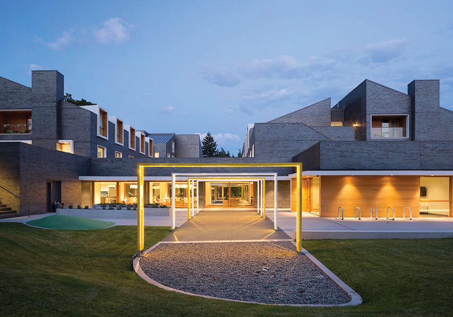 A string of communal areas knit together the four houses on the ground floor. Iron spot brick provides a durable façade, protecting the prefabricated CLT panels that form the building’s primary structural system. Photo by Ema Peter Photography.