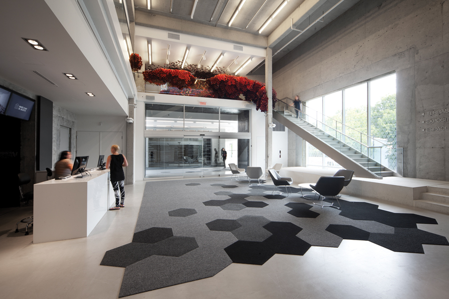 A concrete floor was removed to enlarge the existing lobby into a spacious two-storey space, flanked by staircases to the upper-floor exhibition and reception areas.